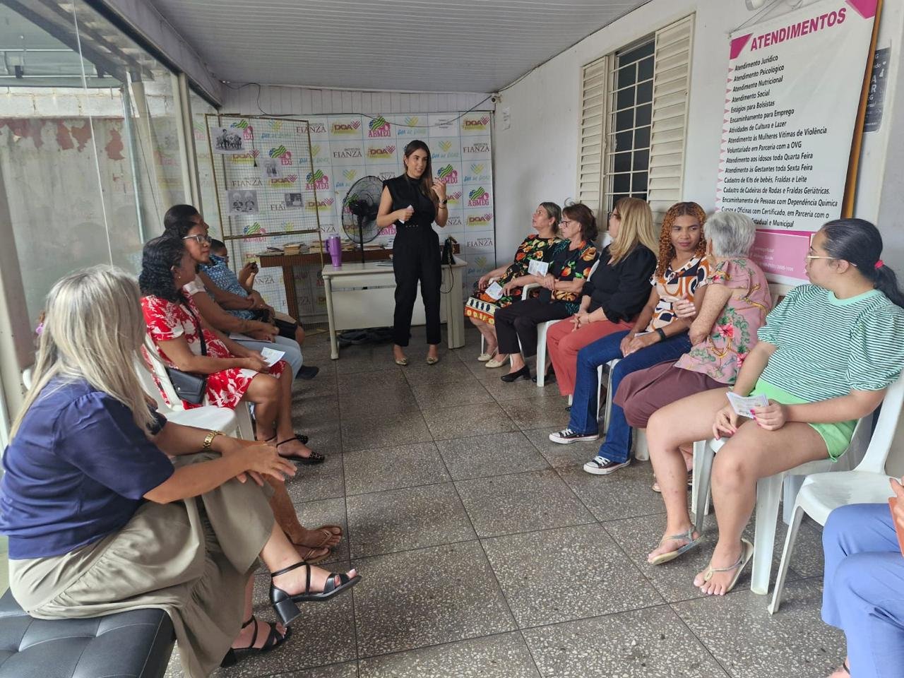 Grupo de mulheres e famílias acolhidas pela ABMEG reunidas em um encontro comunitário